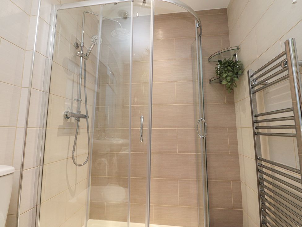 A bathroom with a shower and towel rail at Thieveley Pike View in Burnley