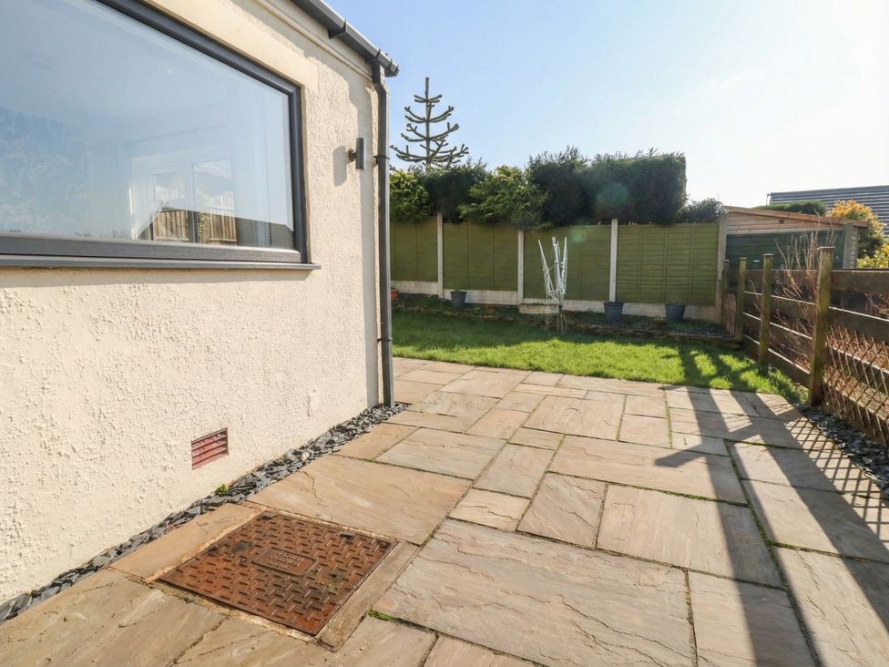 A garden with a stone patio and grass at Thieveley Pike View in Burnley