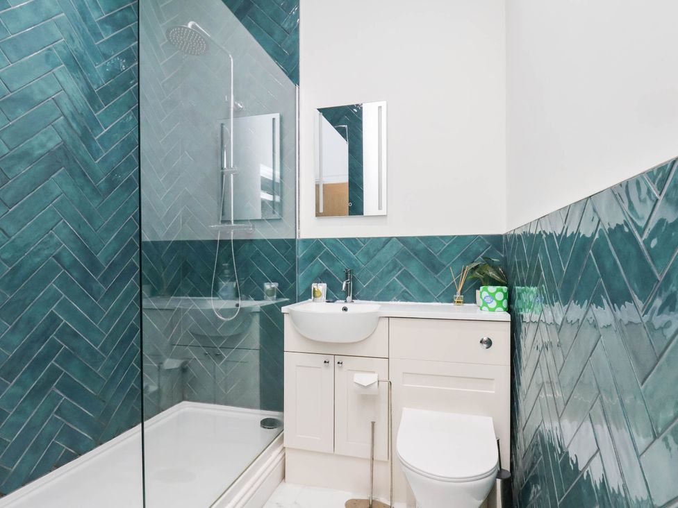 A bathroom with a shower, sink, and toilet at Holmwood