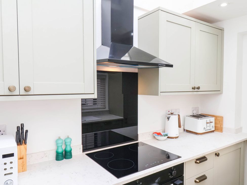 A kitchen with cabinets, stove, and appliances at Holmwood