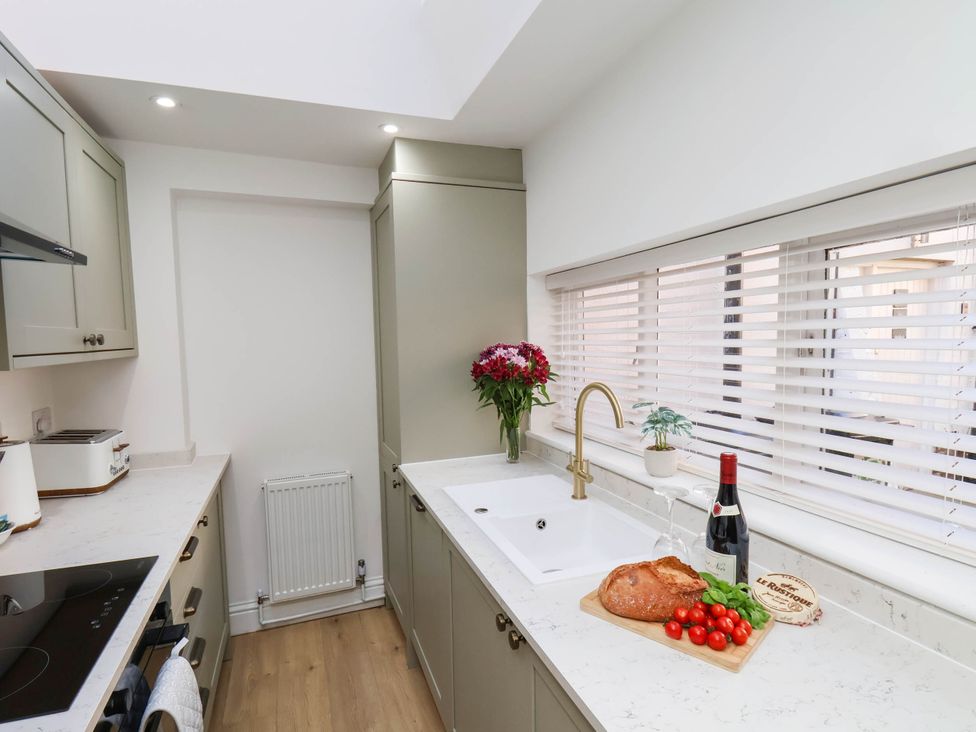 A kitchen with a sink, toaster, and wine bottle at Holmwood
