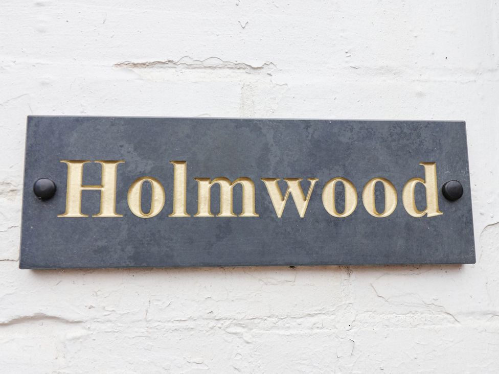 A sign with the name Holmwood displayed on a wall