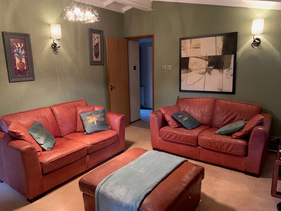 A living room with two sofas and wall art at The Hermitage in Penrith