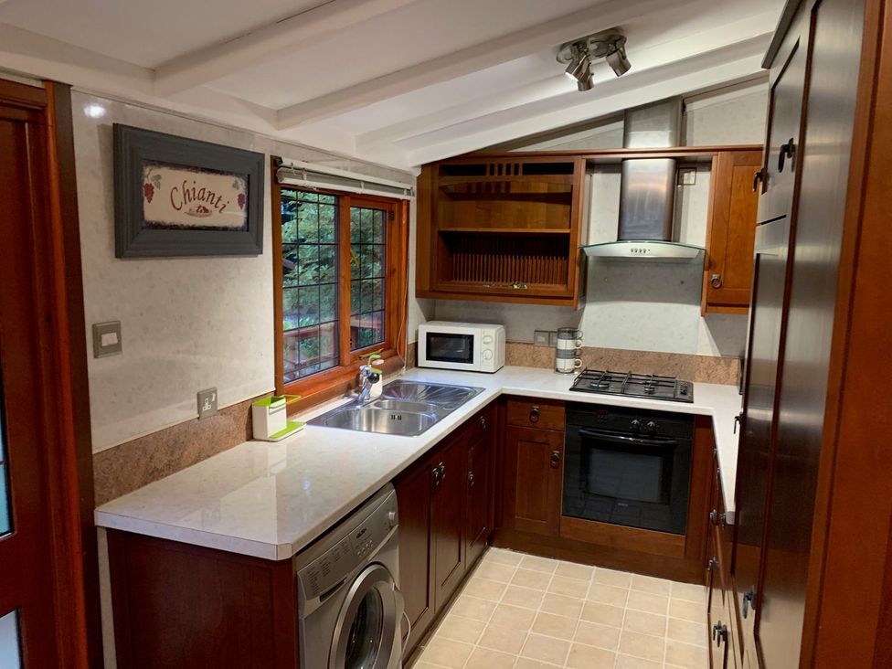 A kitchen with a sink, microwave, and oven at The Hermitage in Penrith
