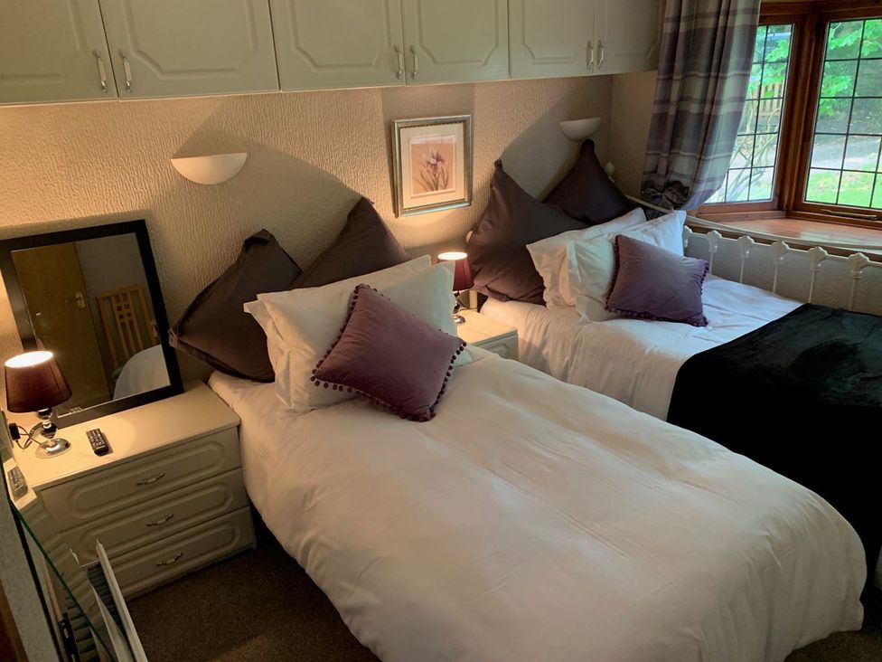 A bedroom with two beds and lamps at The Hermitage in Penrith