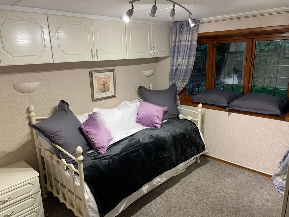 A bedroom with a day bed and a window at The Hermitage in Penrith