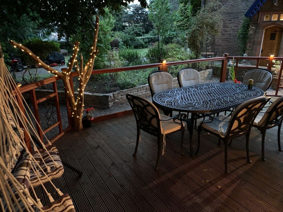 An outdoor porch with a table and chairs at The Hermitage in Penrith
