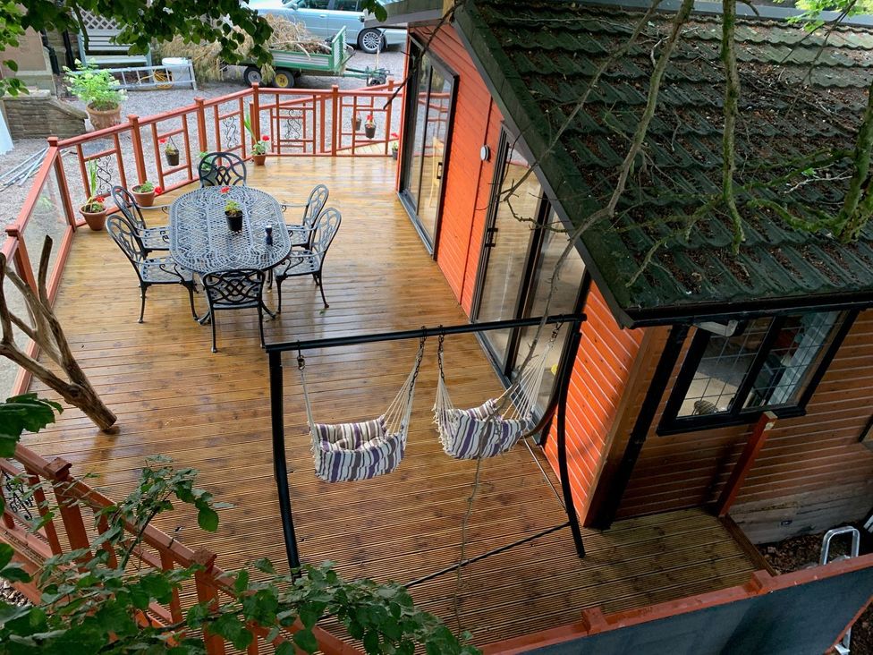 A deck with a table and chairs at The Hermitage in Penrith