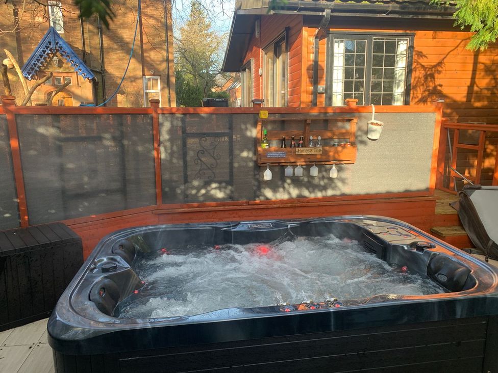 A hot tub in an outdoor area with a bar shelf at The Hermitage in Penrith