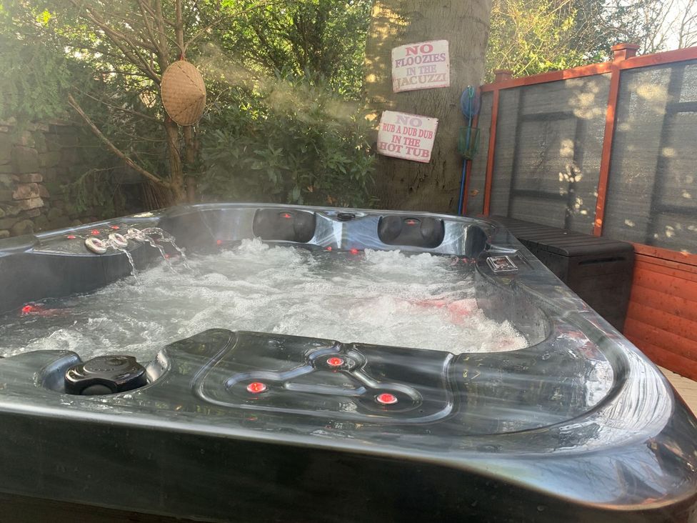 A hot tub with water jets and safety signage at The Hermitage in Penrith