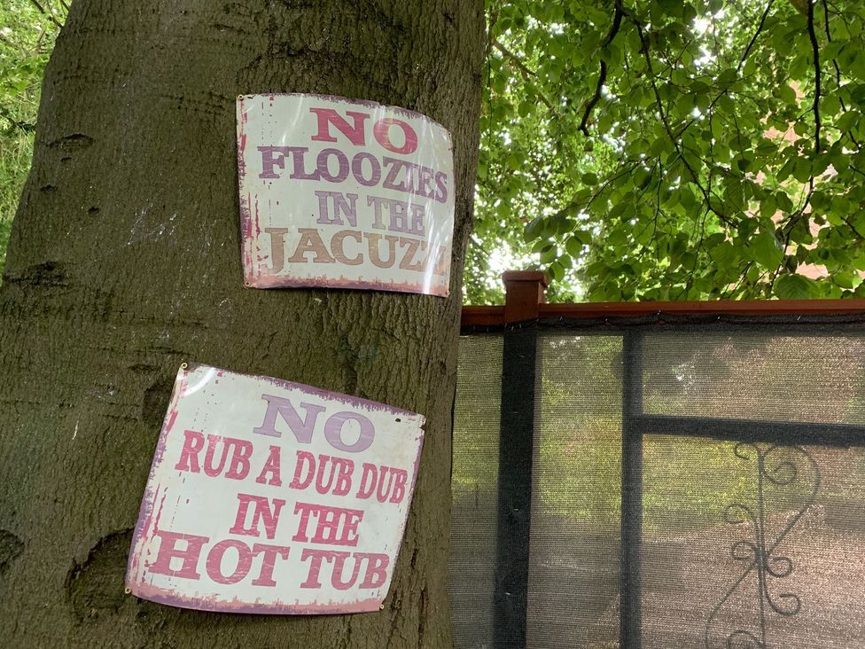 Signs on a tree regarding jacuzzi rules at The Hermitage in Penrith