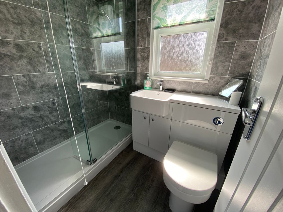 A bathroom with a shower, toilet and sink at Chalet 58 California, Norfolk