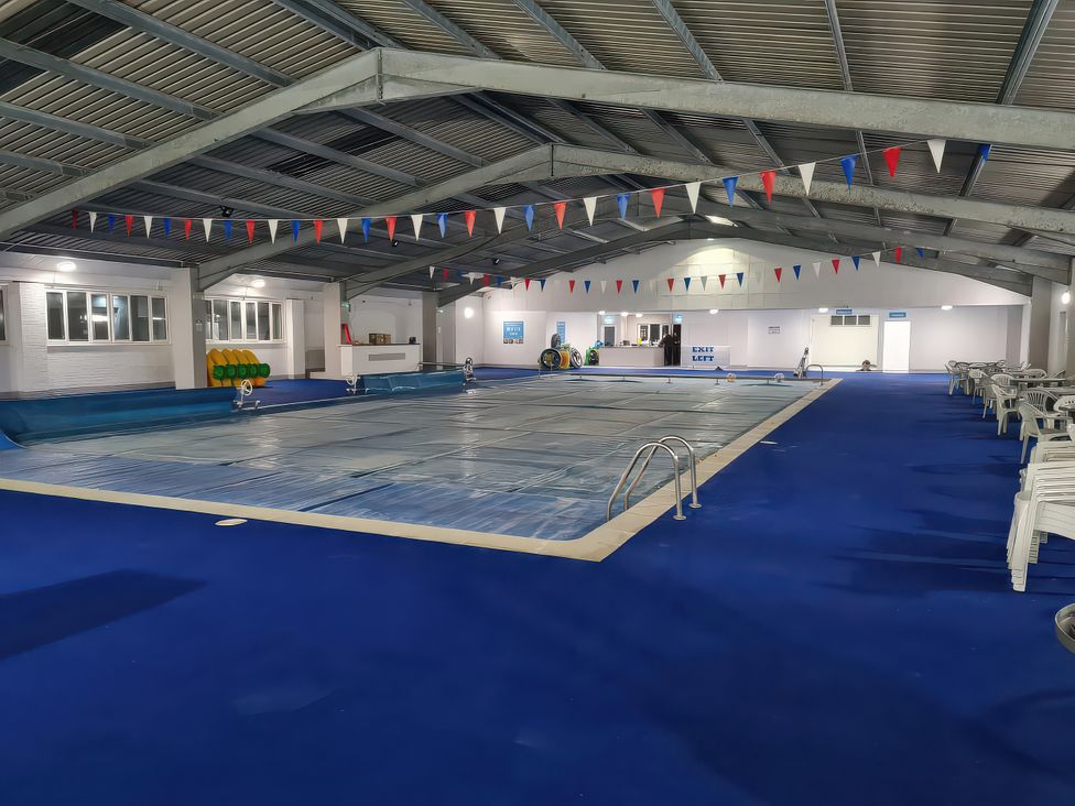 An indoor pool area with covered pool and seating at Chalet 58, California, Norfolk