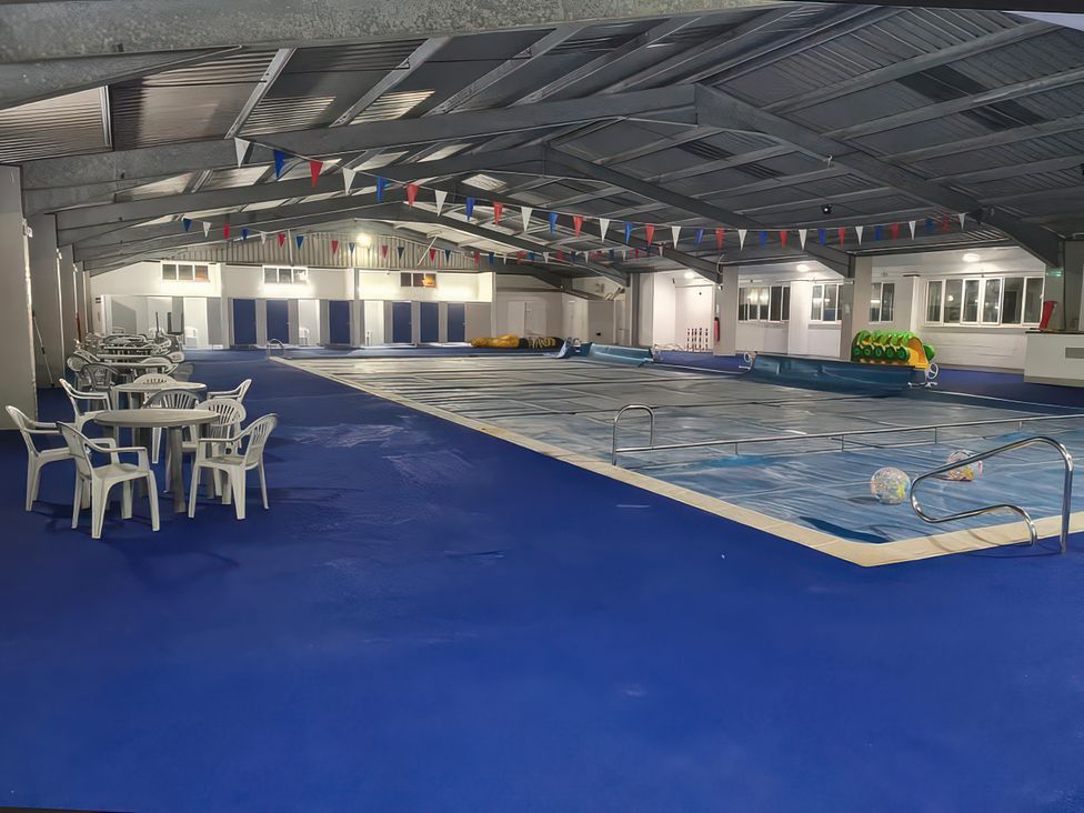 An indoor pool area with tables and chairs at Chalet 58 California, Norfolk
