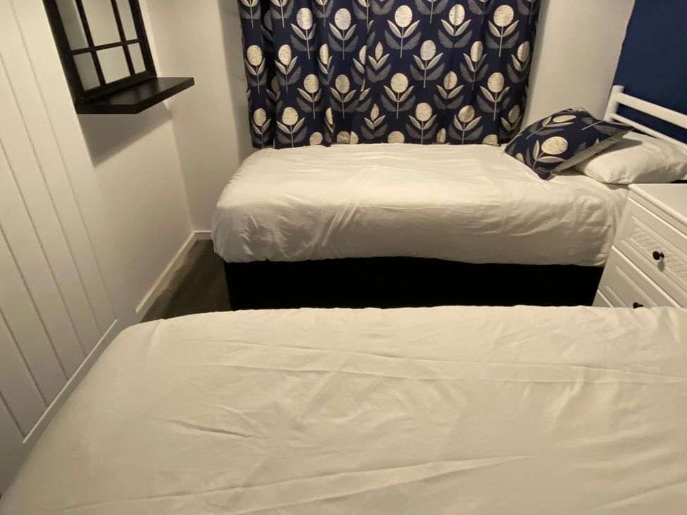 A bedroom with two beds and a shelf at Chalet 333 in California, Norfolk