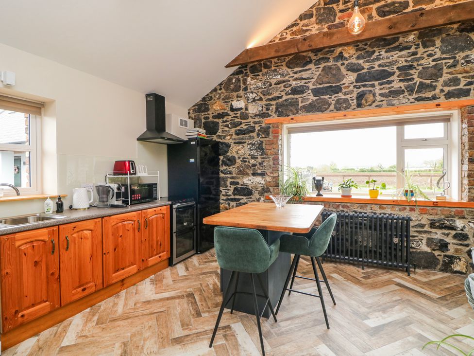 A kitchen with wooden cabinets and dining area at The Stable in Dublin