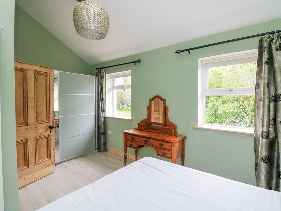 A bedroom with a dressing table and a window at The Stable in Dublin