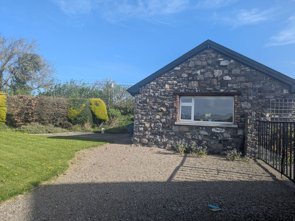 A house with a stone wall and grass area at The Stable in Swords, County Dublin