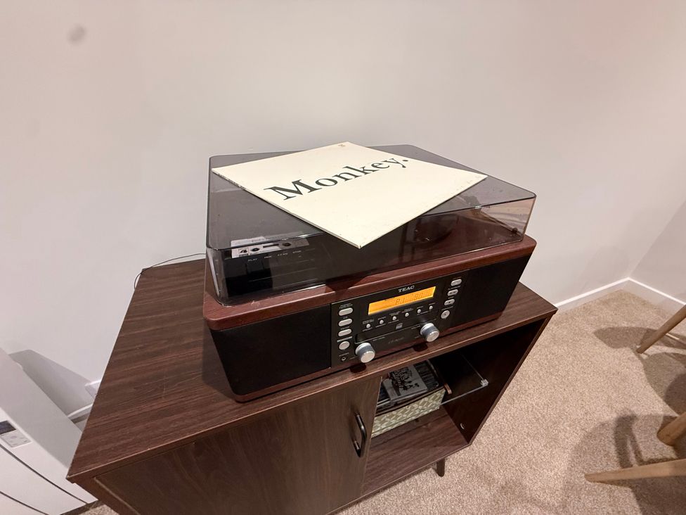 A turntable on a wooden cabinet in the living room at Amber Rose Berwick-upon-Tweed