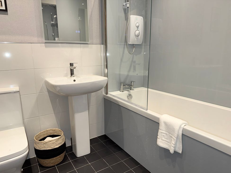 A bathroom with a sink, toilet, bathtub, and shower at Amber Rose in Berwick-upon-Tweed