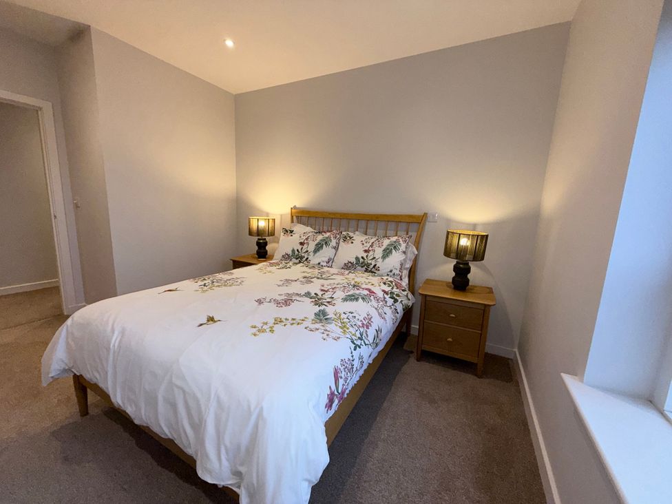 A bedroom with a bed and nightstand at Amber Rose in Berwick-upon-Tweed