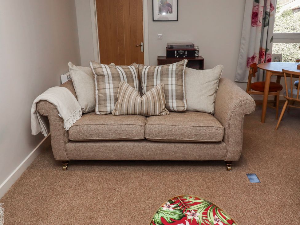 A living room with a sofa and dining table at Amber Rose in Berwick-Upon-Tweed