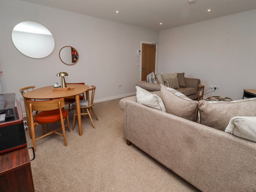 A living room with a sofa and dining table at Amber Rose in Berwick-Upon-Tweed