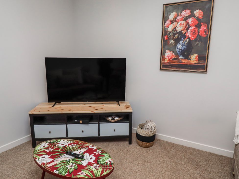 A living room with a television and a coffee table at Amber Rose in Berwick-Upon-Tweed