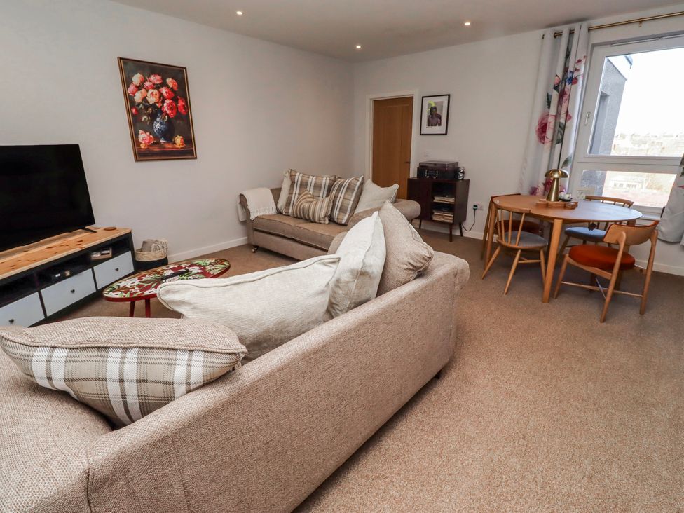A living room with a sofa and dining table at Amber Rose in Berwick-Upon-Tweed