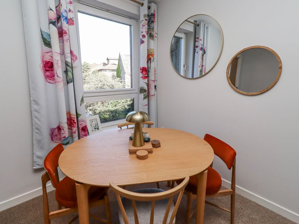 A dining room with a round table and chairs at Amber Rose in Berwick-Upon-Tweed