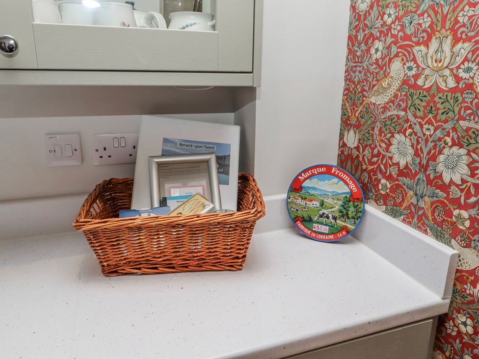 A basket with items and a decorative plate in a kitchen at Amber Rose in Berwick-Upon-Tweed