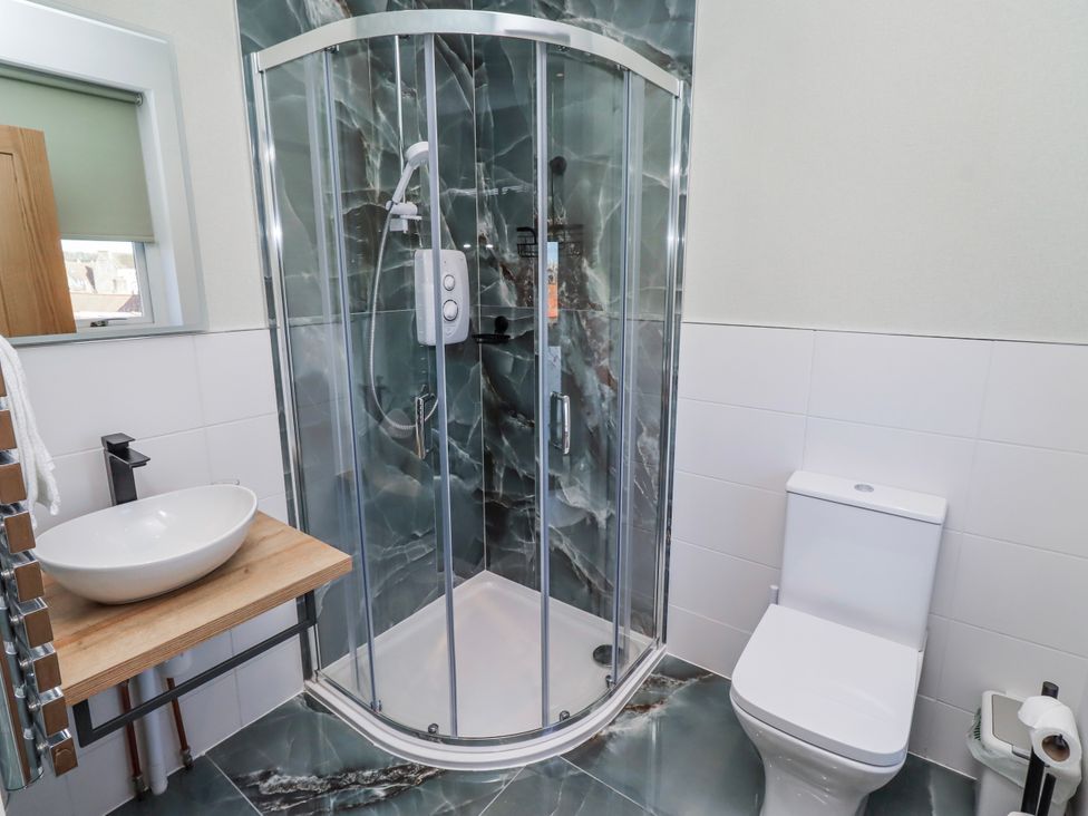 A bathroom with a shower, toilet, and sink at Amber Rose in Berwick-Upon-Tweed