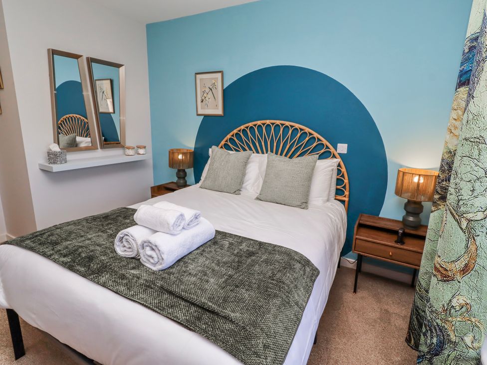 A bedroom with a bed and mirrors at Amber Rose in Berwick-Upon-Tweed