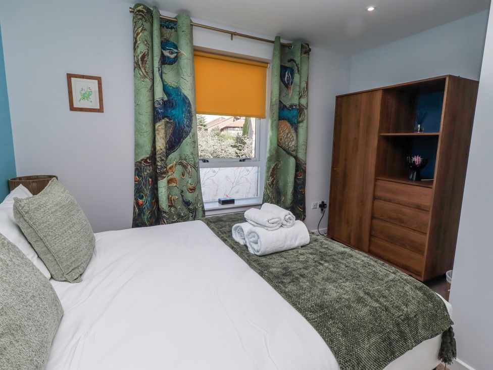 A bedroom with a bed and dresser at Amber Rose Berwick-Upon-Tweed