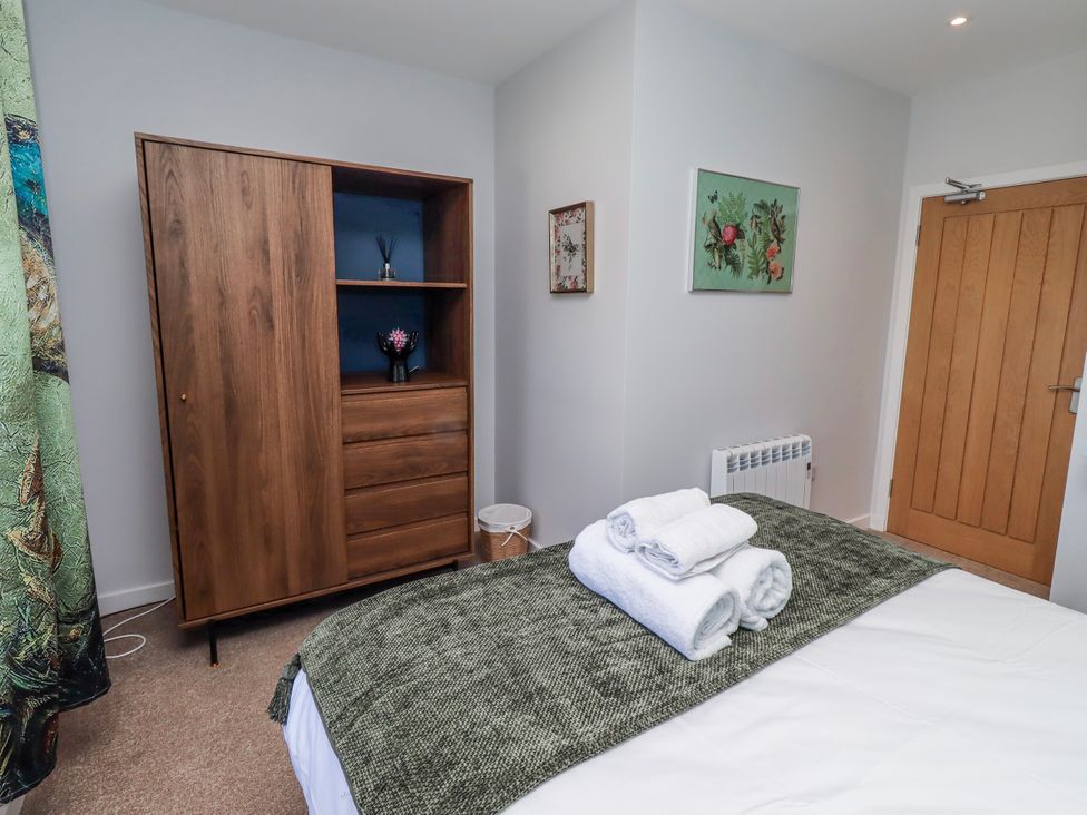 A bedroom with a bed and wardrobe at Amber Rose in Berwick-Upon-Tweed