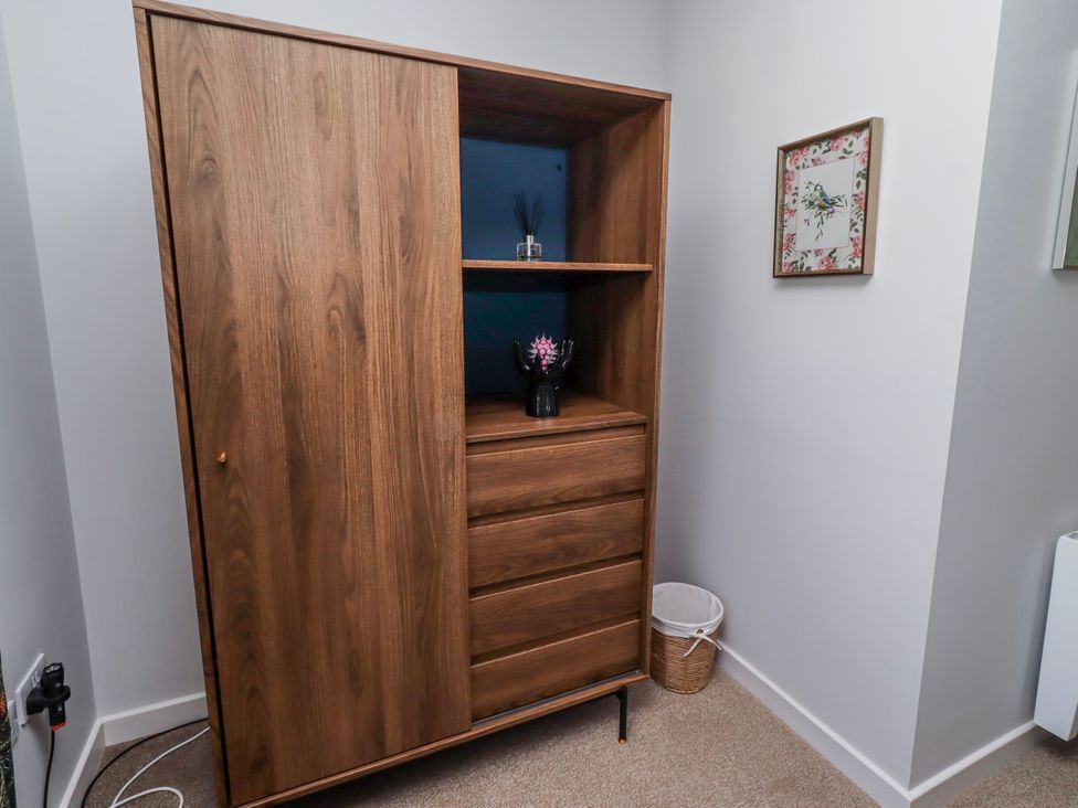 A wardrobe with shelves, drawer and decorative items at Amber Rose in Berwick-Upon-Tweed