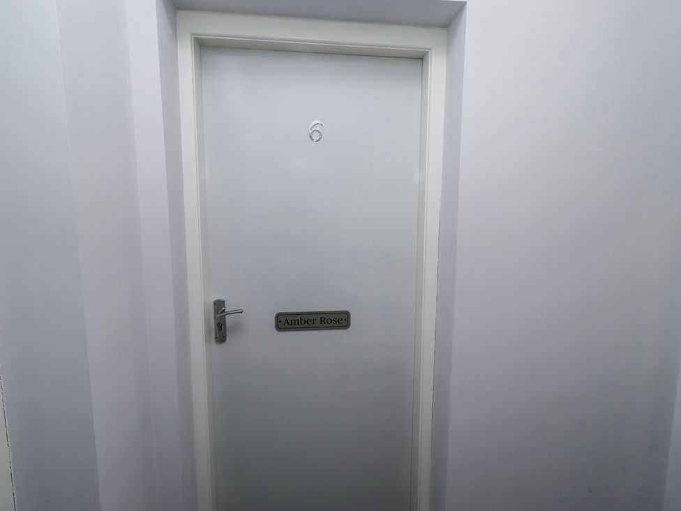 A door with a nameplate and number 6 at Amber Rose in Berwick-Upon-Tweed