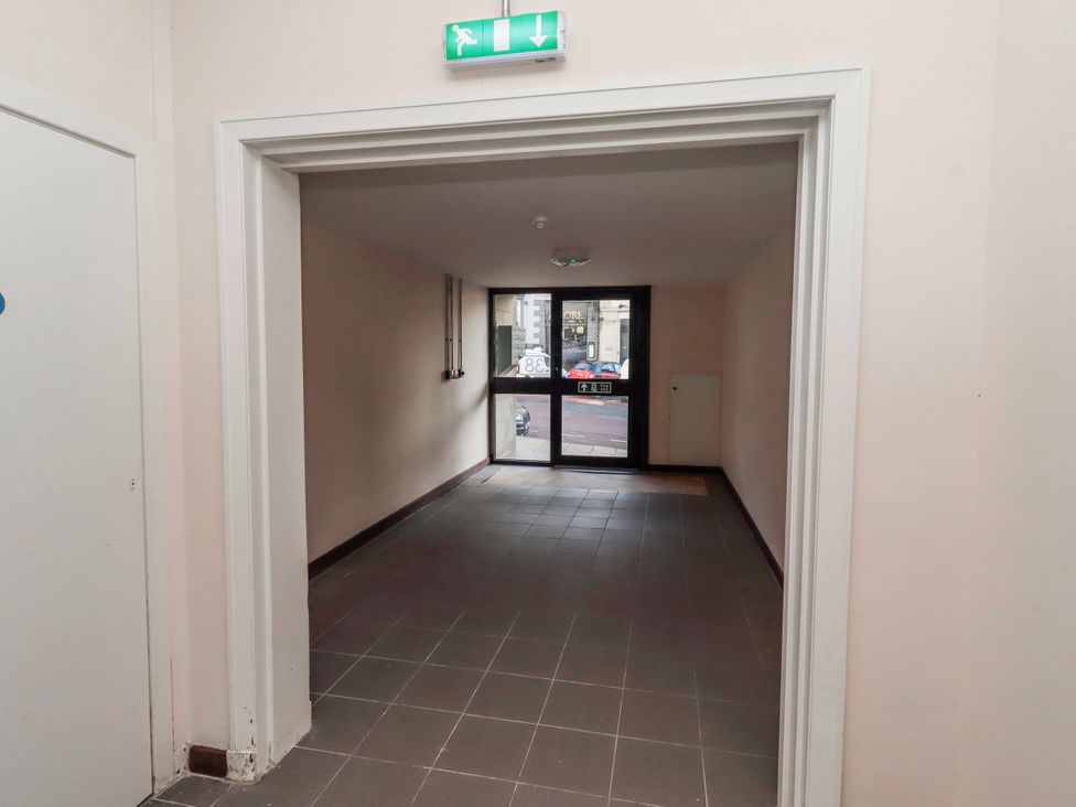 A hallway with an exit sign and a door at Amber Rose in Berwick-Upon-Tweed