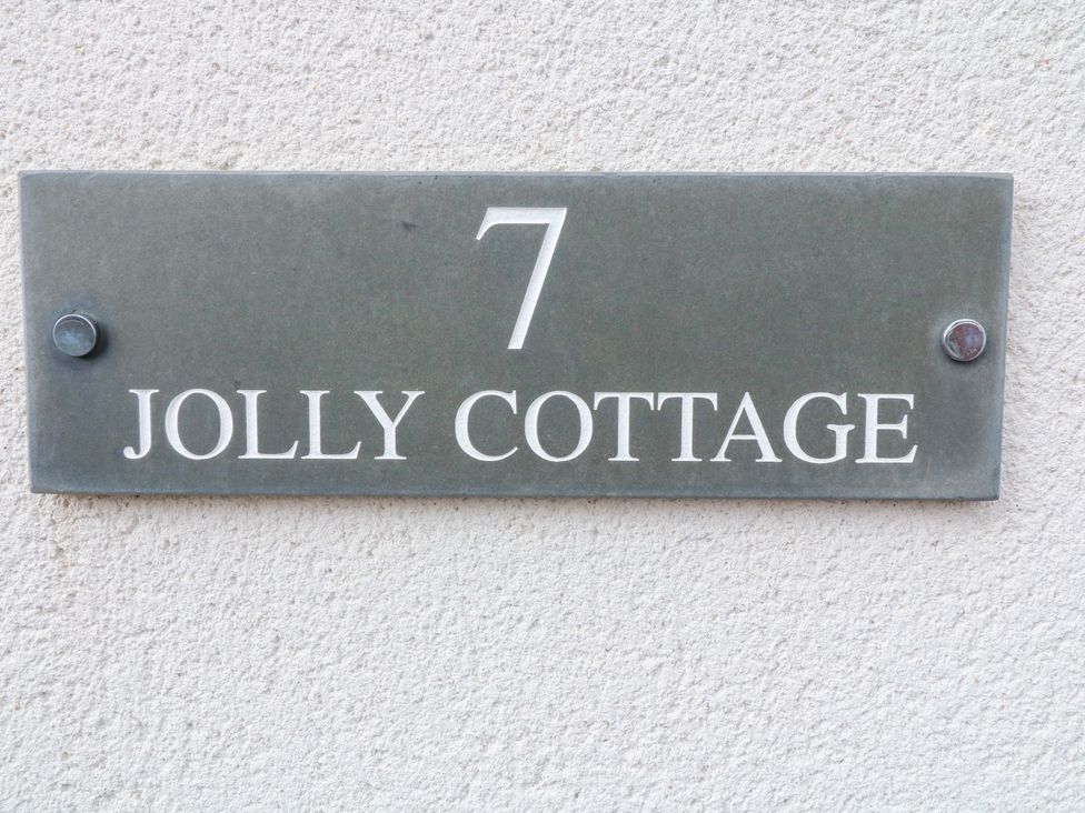 A building plaque displaying the number 7 and Jolly Cottage in Derby
