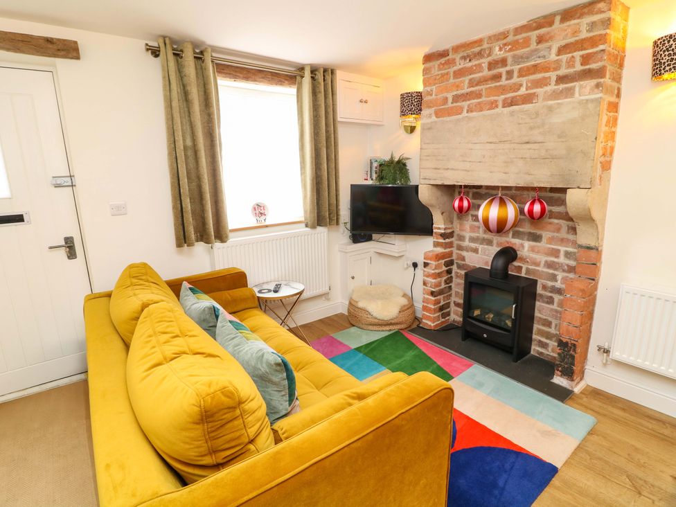 A living room with a sofa and a television at Jolly Cottage in Derby
