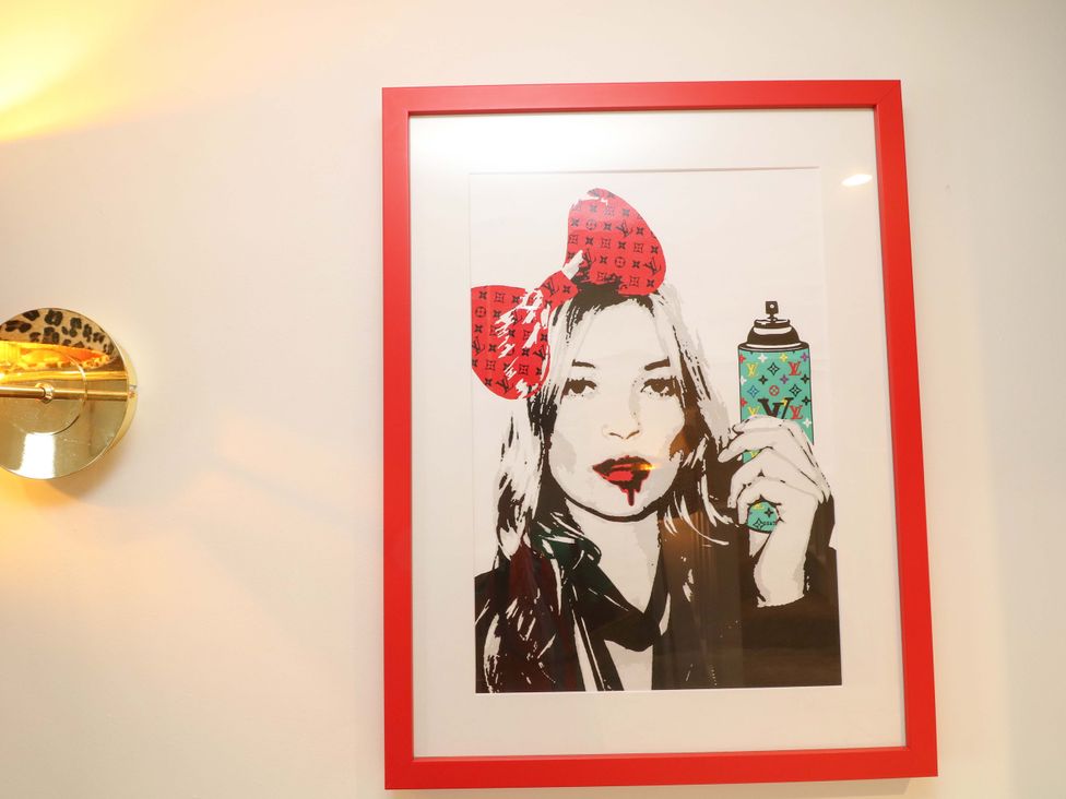 A framed artwork featuring a painted figure holding a spray can at Jolly Cottage in Derby