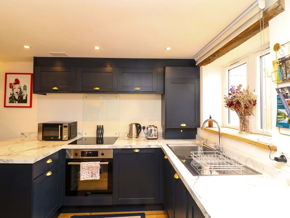 A kitchen with a sink and appliances at Jolly Cottage in Derby