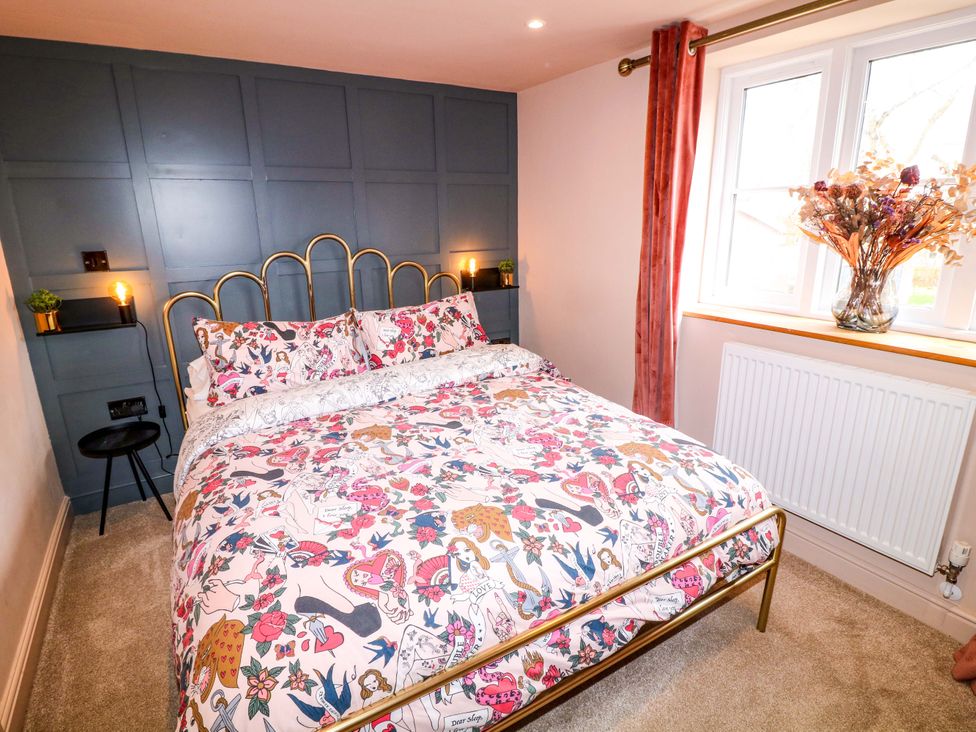 A bedroom with a bed and window at Jolly Cottage in Derby