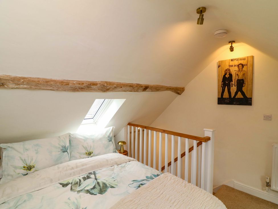 A bedroom with bedding and artwork at Jolly Cottage in Derby