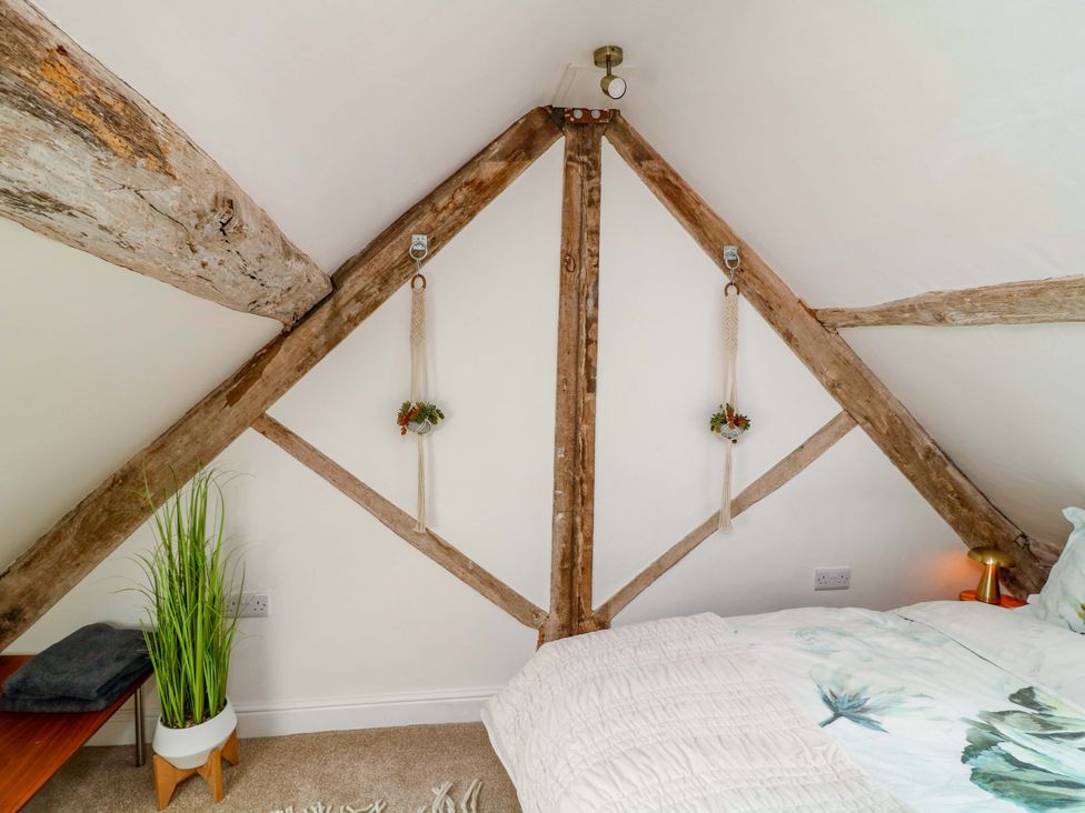 A bedroom with wood beams and a bed at Jolly Cottage Derby
