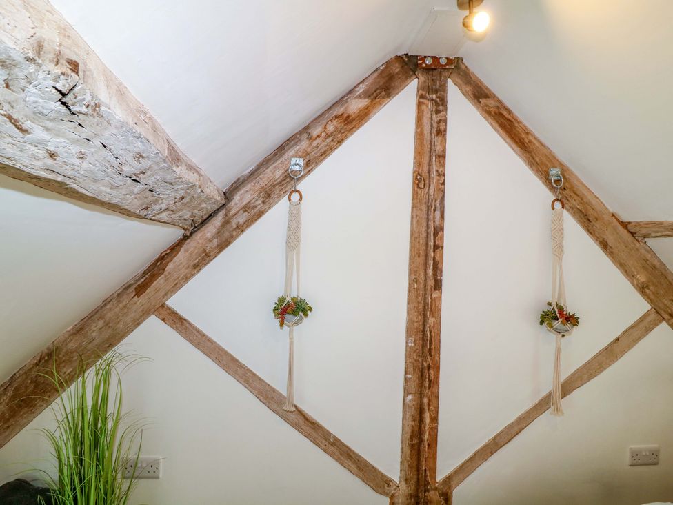 A wall with wooden beams and hanging planters at Jolly Cottage in Derby