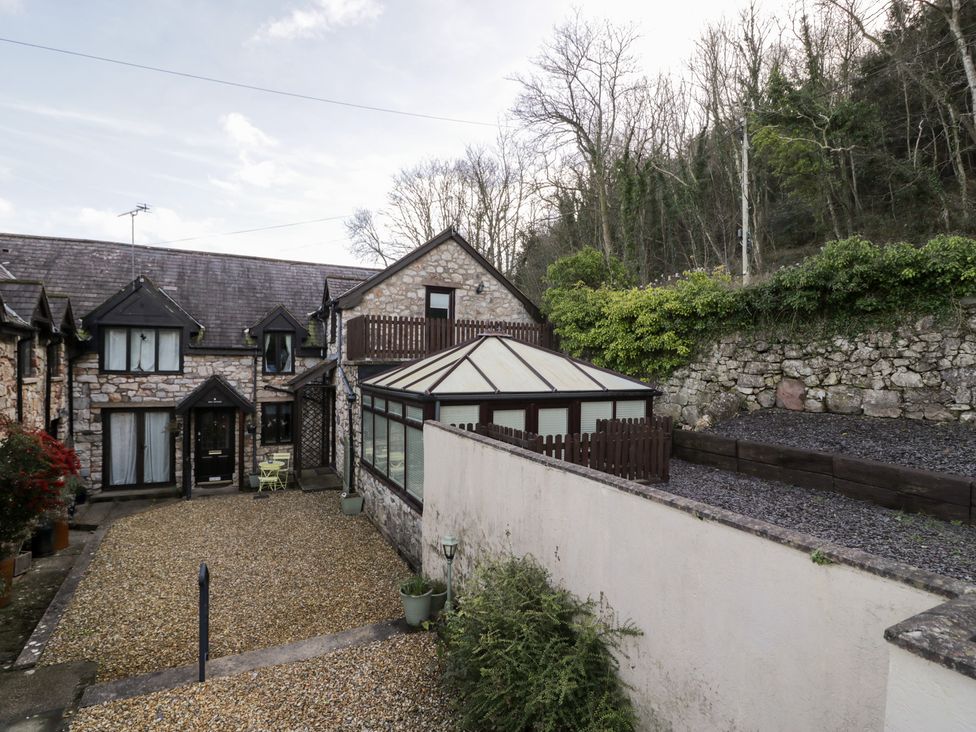 An outdoor area with a gravel garden and a glasshouse at Ivy Cottage in Abergele