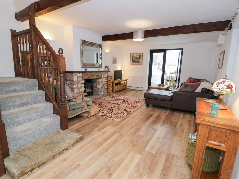 A living room with a sofa and fireplace at Ivy Cottage in Abergele