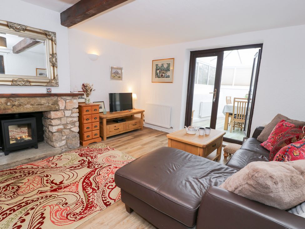A living room with a sofa and television at Ivy Cottage in Abergele
