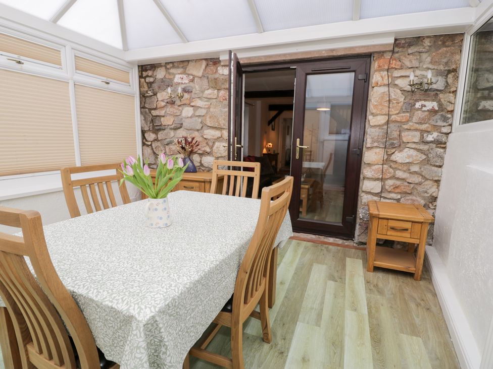 A conservatory with a table and chairs at Ivy Cottage in Abergele